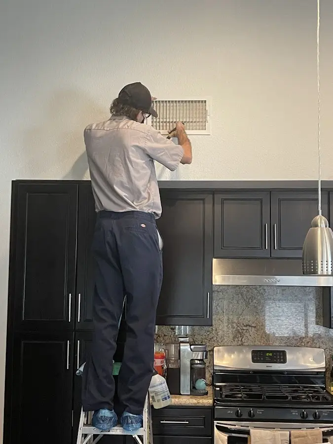 Technician inspecting an air vent during HVAC service in Altamonte Springs